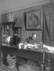 Franse componist Jules Massenet zittend aan zijn bureau